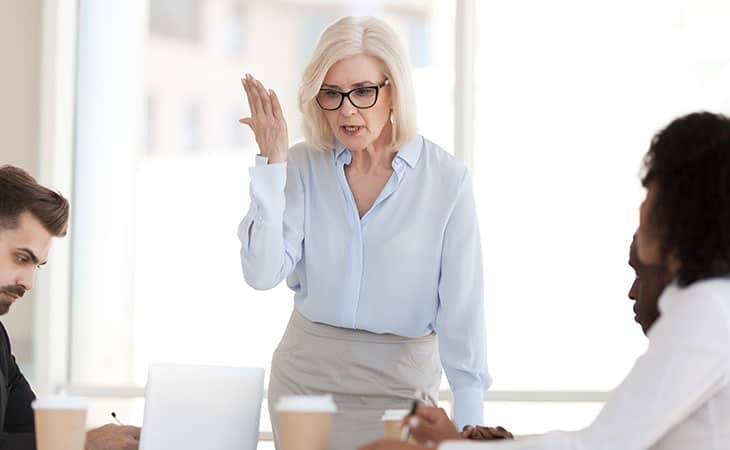Mastering Interpersonal Skills: Your Guide To Success Evinex Corporation | Staffing Agency a woman with her hand up talking in an office