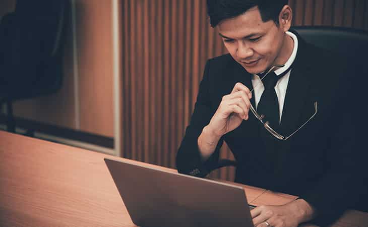 How To Hire An Employee: A Step-By-Step Complete Guide Evinex Corporation | Staffing Agency man wearing a suit and holding his glasses