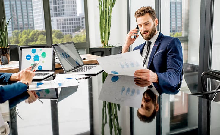 100+ Essential Business Analyst Interview Questions Evinex Corporation | Staffing Agency man-phone-papers-hand-table