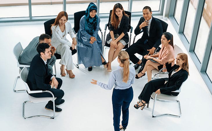 How To Hire An Employee: A Step-By-Step Complete Guide Evinex Corporation | Staffing Agency woman giving a speech to diverse people