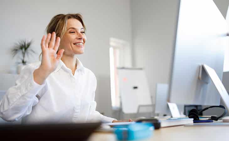 How To Hire An Employee: A Step-By-Step Complete Guide Evinex Corporation | Staffing Agency woman waving at the computer screen