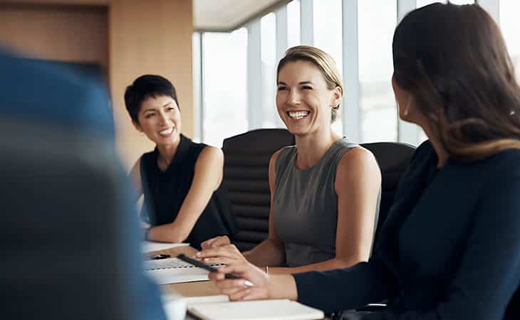 How To Hire An Employee: A Step-By-Step Complete Guide Evinex Corporation | Staffing Agency women smiling in a meeting at the office