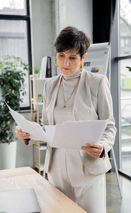 Sales Manager Job Description: Attract And Hire Top Talent Evinex Corporation | Staffing Agency a woman holding and looking at papers
