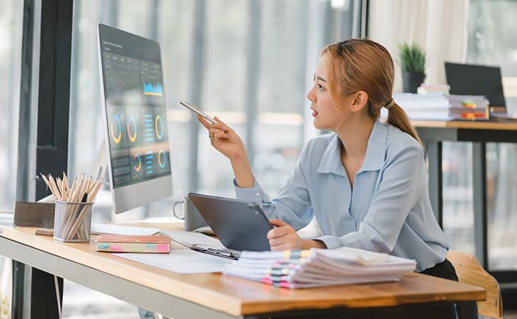 What Is Workforce Management? Key Benefits Evinex Corporation | Staffing Agency a woman in an office pointing at a screen