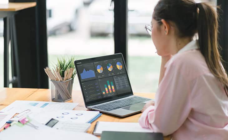What Is Workforce Management? Key Benefits Evinex Corporation | Staffing Agency a woman looking at charts in her laptop