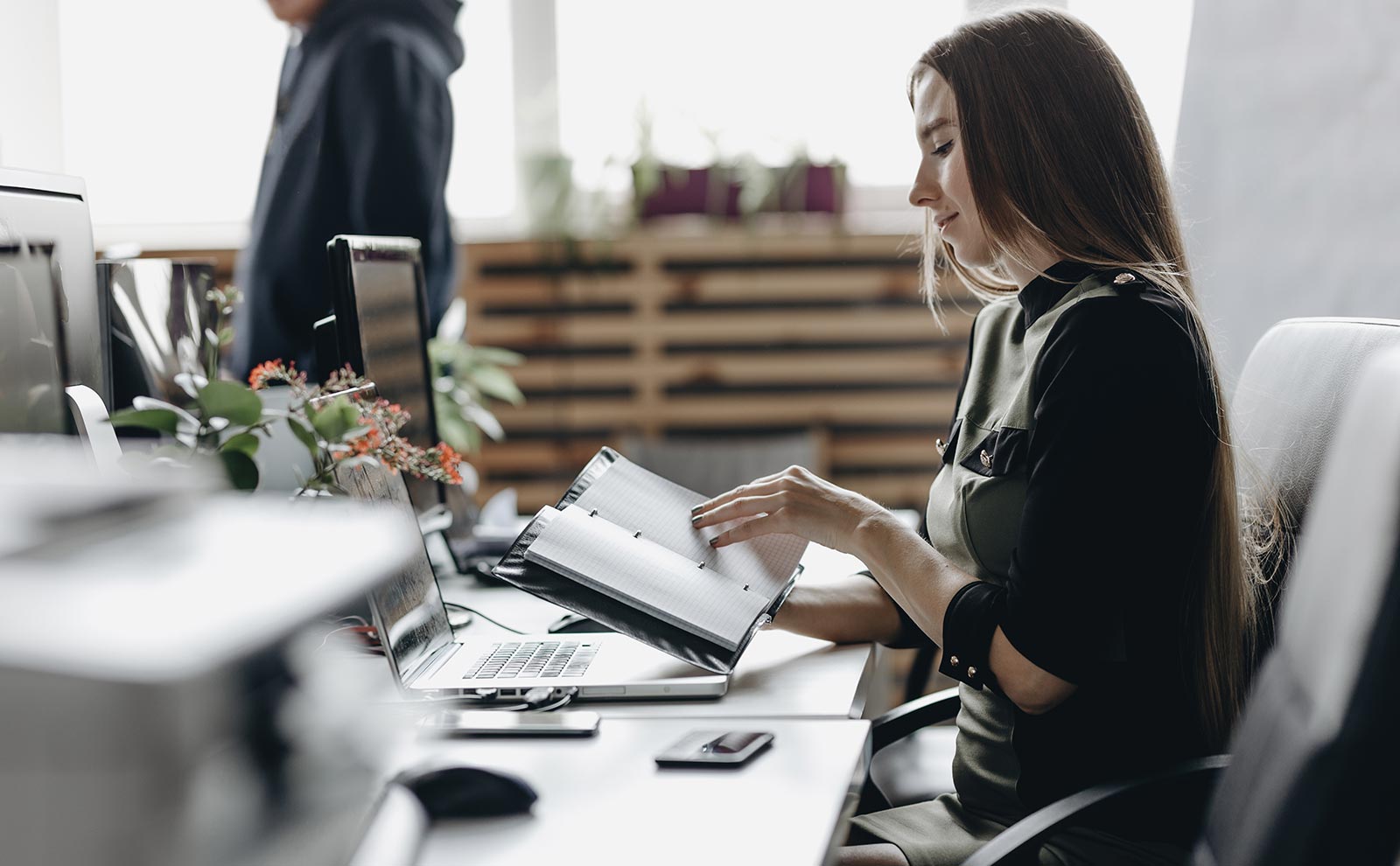 a woman using her agenda in the office desk