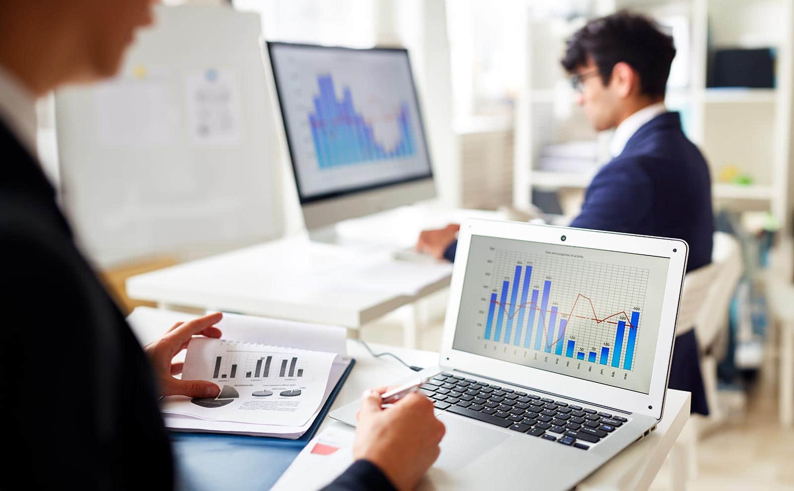 two businessmen working looking at several charts