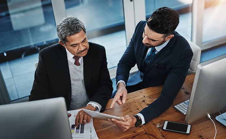 100+ Interview Questions For The Perfect Executive Assistant Evinex Corporation | Staffing Agency two-men-talking-office-tablet