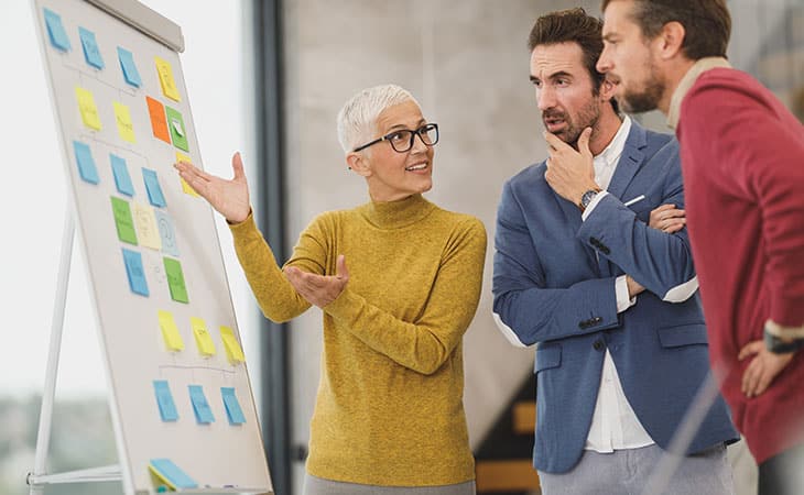 100+ Interview Questions For The Perfect Executive Assistant Evinex Corporation | Staffing Agency woman-pointing-board-post-its