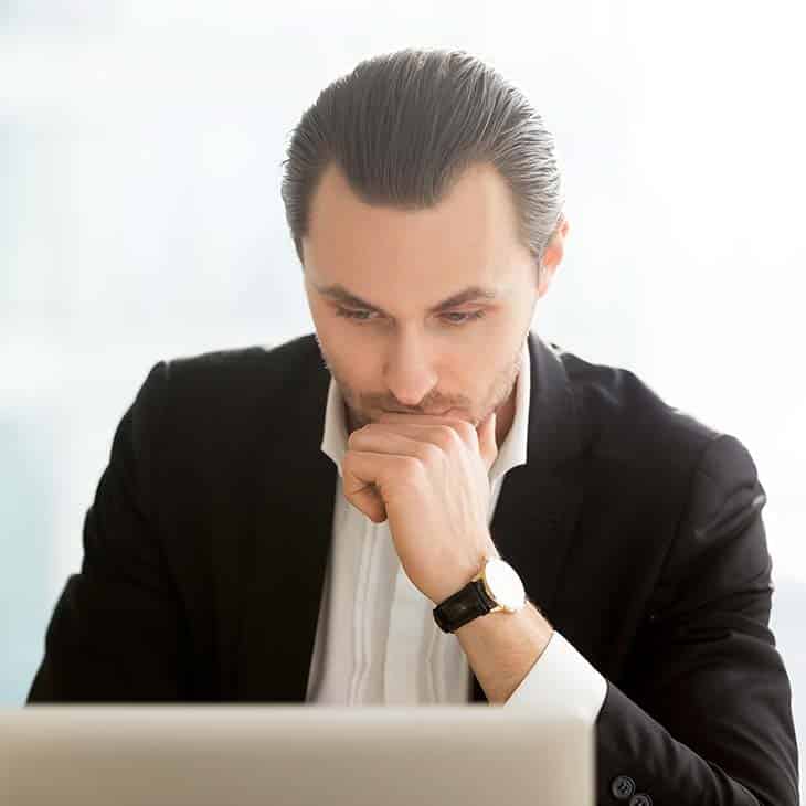 Background Check Questions: A Guide For Effective Hiring Evinex Corporation | Staffing Agency focused businessman looking at computer