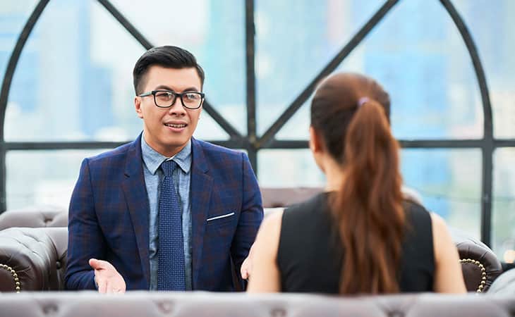 Background Check Questions: A Guide For Effective Hiring Evinex Corporation | Staffing Agency man with his hands open while talking to a woman