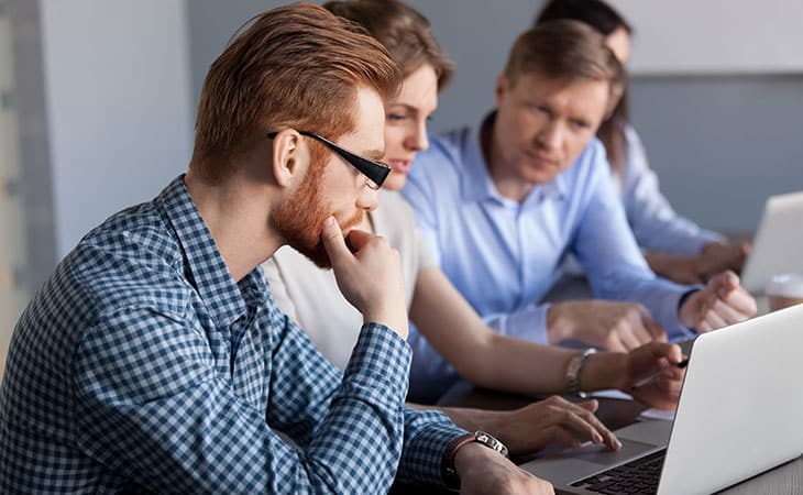 What Is Database Migration? A Step-By-Step Guide Evinex Corporation | Staffing Agency a group of thoughtful people looking at laptop