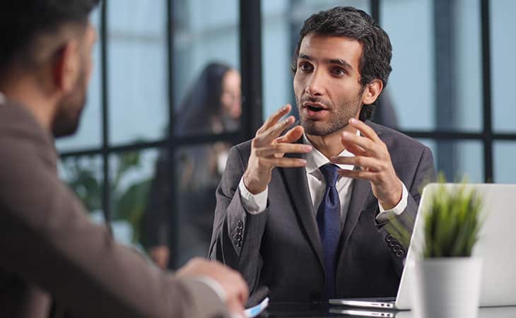 100+ Sales Manager Interview Questions With Answers Evinex Corporation | Staffing Agency a man in a suit speaking and making gestures to a man