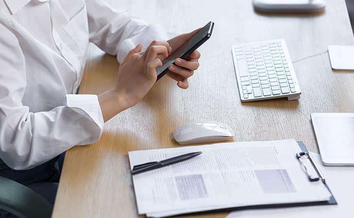 Best Fonts For Your Resume: Stand Out Professionaly Evinex Corporation | Staffing Agency detail of a persons hands checking the phone and papers