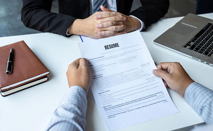 Best Fonts For Your Resume: Stand Out Professionaly Evinex Corporation | Staffing Agency detail of hands holding a paper resume