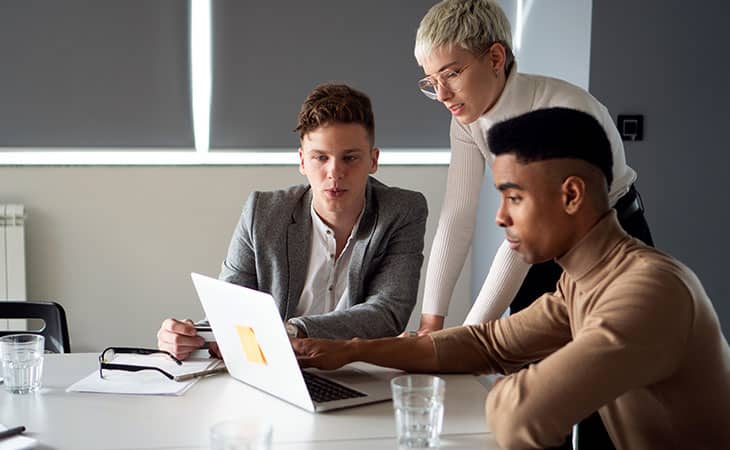What Is Database Migration? A Step-By-Step Guide Evinex Corporation | Staffing Agency people discussing something around a laptop