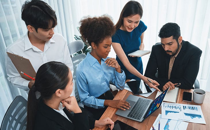 What Is A Chief Of Staff? Key Responsibilities And More Evinex Corporation | Staffing Agency people in an office meeting around a computer