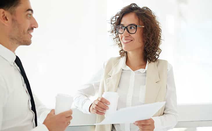100+ Sales Manager Interview Questions With Answers Evinex Corporation | Staffing Agency woman holding documents while talking to a man
