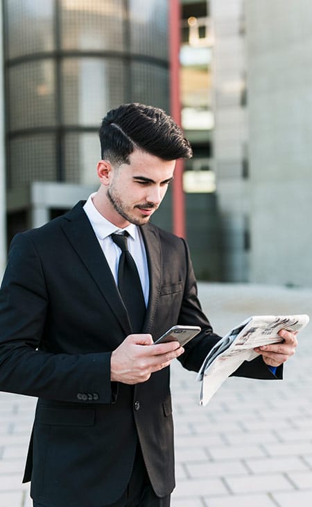 100+ Chief Of Staff Interview Questions. Find Top Leaders Evinex Corporation | Staffing Agency a businessman in the street looking at a newspaper and a phone