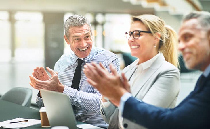 Hr Issues And Challenges: Solutions For The Modern Workplace Evinex Corporation | Staffing Agency a group of workers clapping and smiling during a meeting
