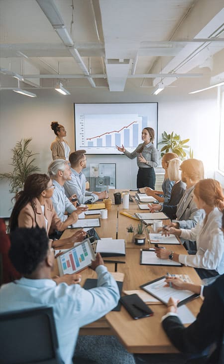 Hr Issues And Challenges: Solutions For The Modern Workplace Evinex Corporation | Staffing Agency a team meeting with a woman presenting a growth chart