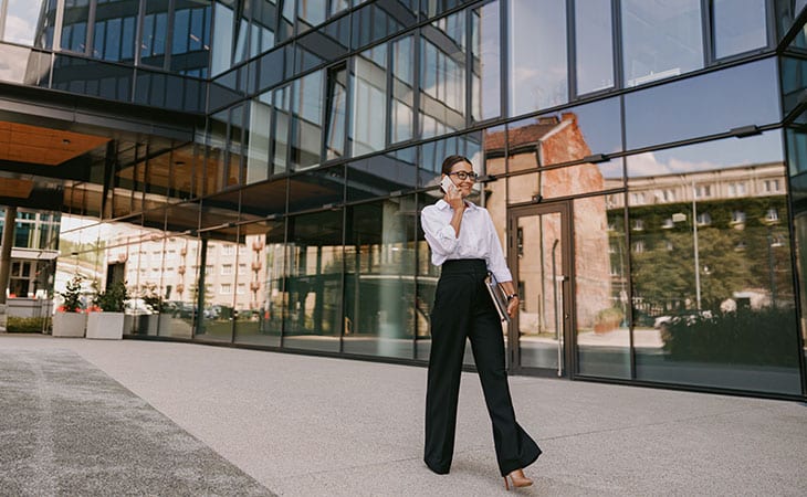 100+ Chief Of Staff Interview Questions. Find Top Leaders Evinex Corporation | Staffing Agency a woman walking in the street while talking on the phone