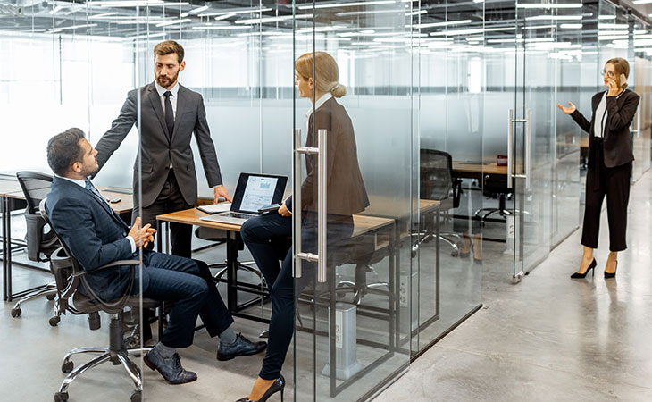 people talking in a modern glass walled office