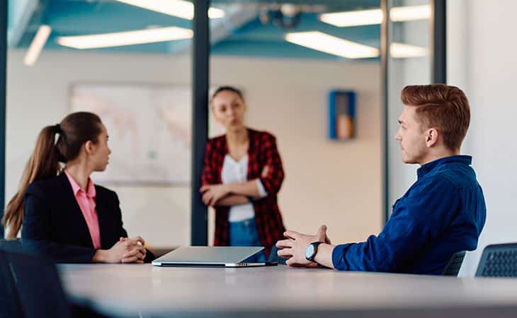 How To Conduct A Job Interview For Better Hiring Decisions Evinex Corporation | Staffing Agency three people discussing during a business meeting in an office