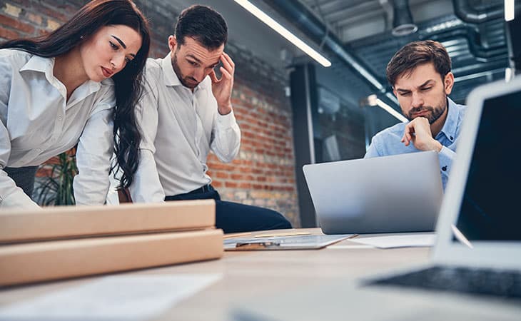 Hr Issues And Challenges: Solutions For The Modern Workplace Evinex Corporation | Staffing Agency three people reviewing information and documents on an office table