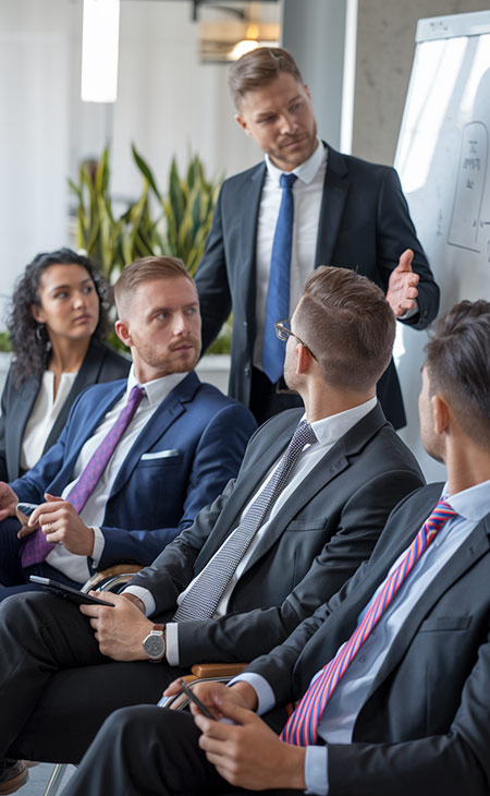 How To Lead A Team: Strategies For Effective Leadership Evinex Corporation | Staffing Agency a businessman speaking to a group of business people