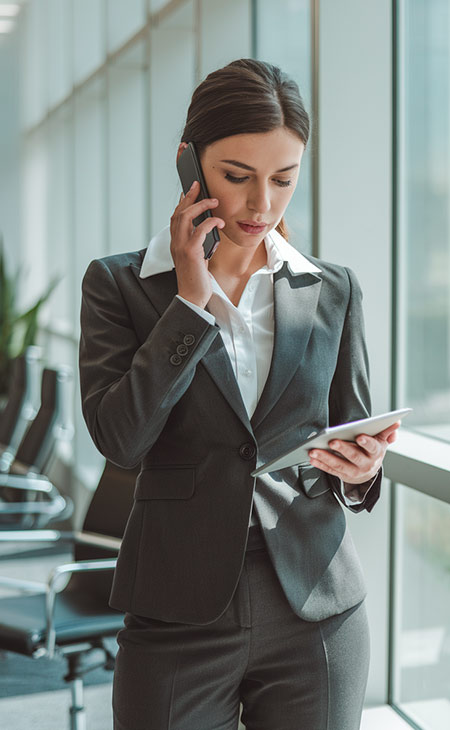 a businesswoman making a call and holding a tablet