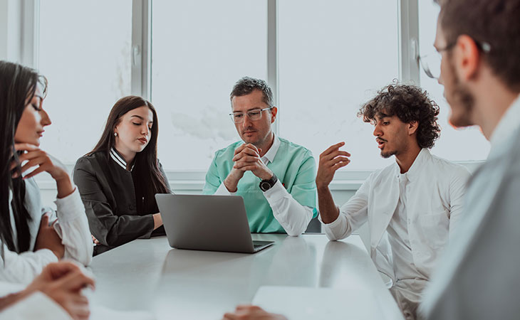 How To Lead A Team: Strategies For Effective Leadership Evinex Corporation | Staffing Agency a group of people in a meeting talking
