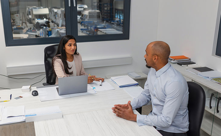 How To Impress In An Interview: Tips To Stand Out Evinex Corporation | Staffing Agency a man and a woman talking in an office