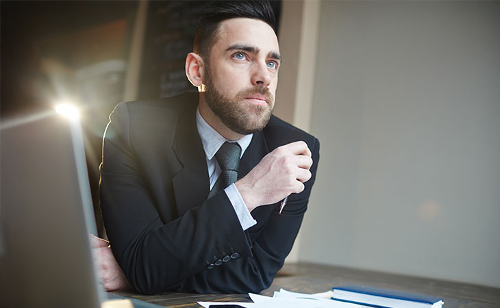 a man in a suit is thinking in an office