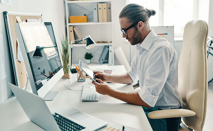 How To Write A Resignation Letter: Step-By-Step Guide Evinex Corporation | Staffing Agency a man in an office using a tablet