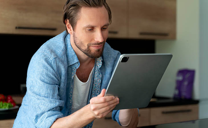 Interview Cheat Sheet: Essential Tips To Ace Your Interview Evinex Corporation | Staffing Agency a man in his kitchen looking at a tablet