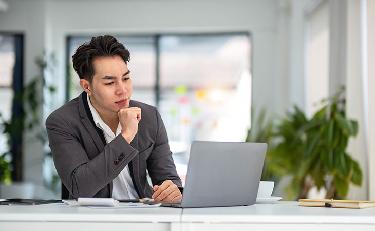 a man with a laptop is reflecting in an office