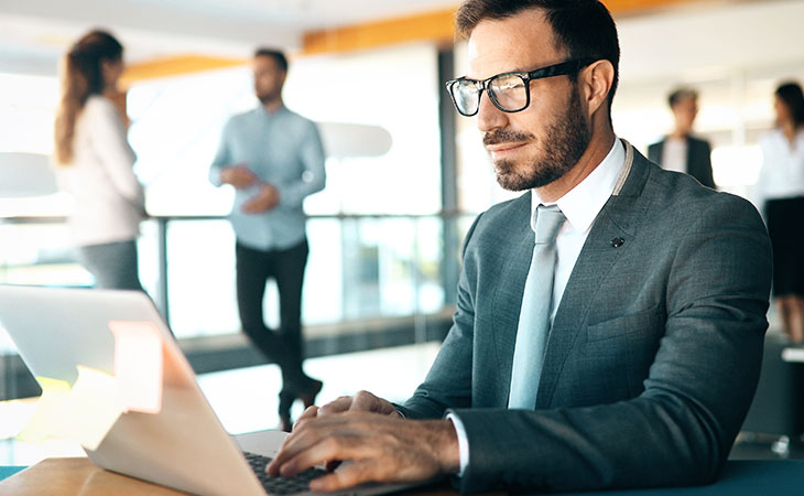 How To Write A Resignation Letter: Step-By-Step Guide Evinex Corporation | Staffing Agency a man writing in the computer in an office