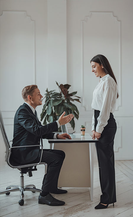 a manager talks to an employee in an office setup