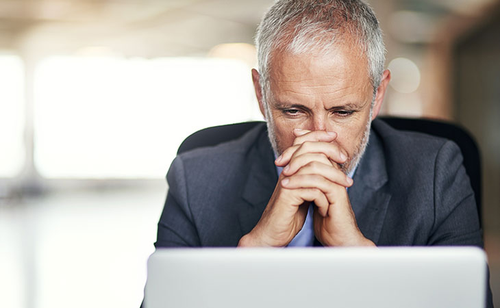 How To Write A Resignation Letter: Step-By-Step Guide Evinex Corporation | Staffing Agency a thoughtful man looking at laptop