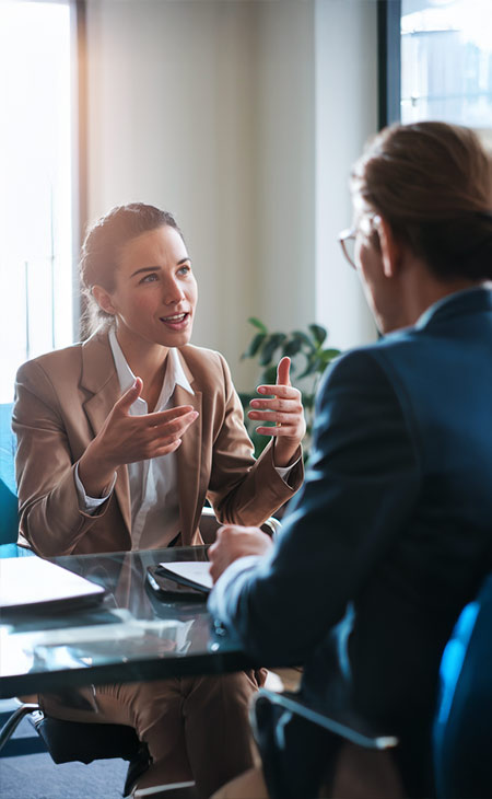 a woman is explaining something to a man in a meeting