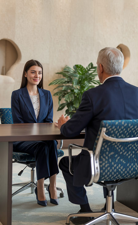 a woman is in an interview with an older employer in an office