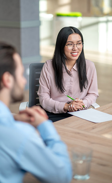 a woman is smiling at an interview table