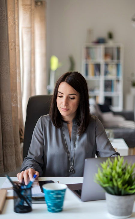 How To Lead A Team: Strategies For Effective Leadership Evinex Corporation | Staffing Agency a woman looking down while working on her laptop