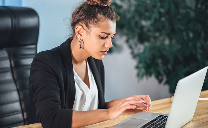 How To Impress In An Interview: Tips To Stand Out Evinex Corporation | Staffing Agency a woman using a laptop