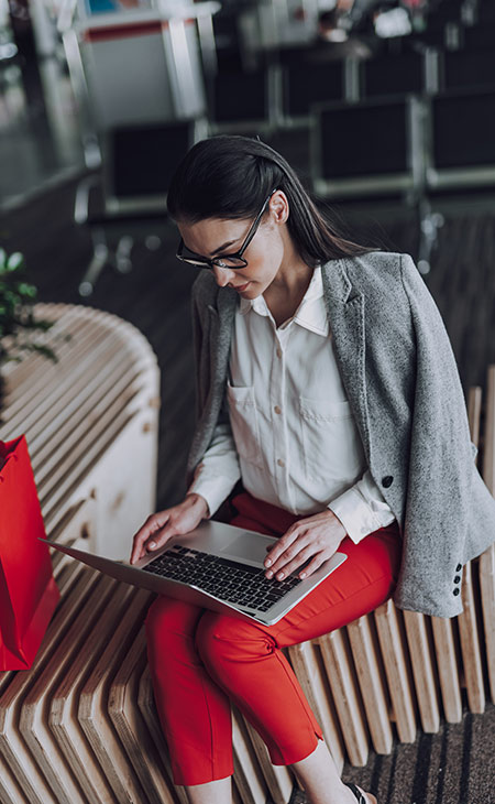 a woman with a laptop is in a travel seating area
