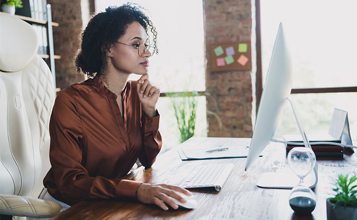 a woman with her hand in her chin working in an office