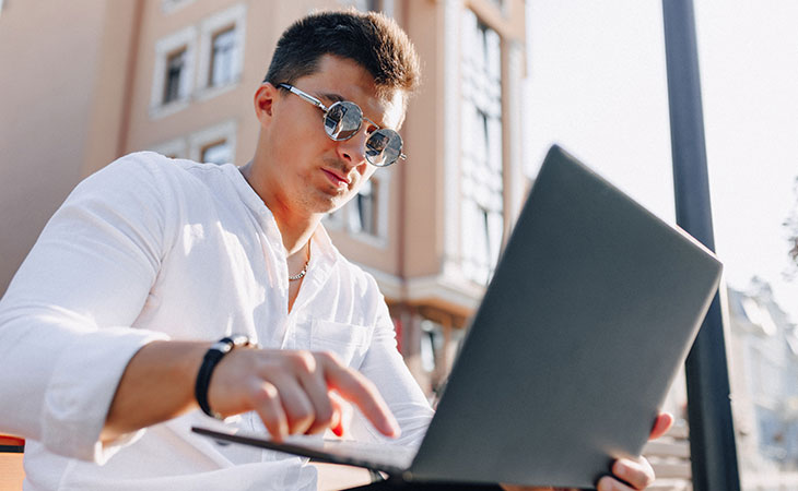 How To Write A Resignation Letter: Step-By-Step Guide Evinex Corporation | Staffing Agency a young guy using a laptop in the street