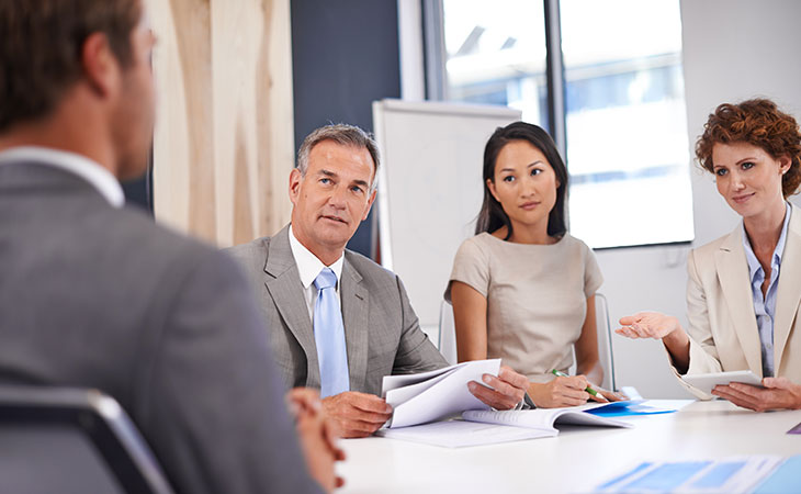 an interview panel is taking place in a corporate office meeting