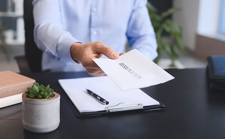 How To Write A Resignation Letter: Step-By-Step Guide Evinex Corporation | Staffing Agency detail of hands giving a resignation letter